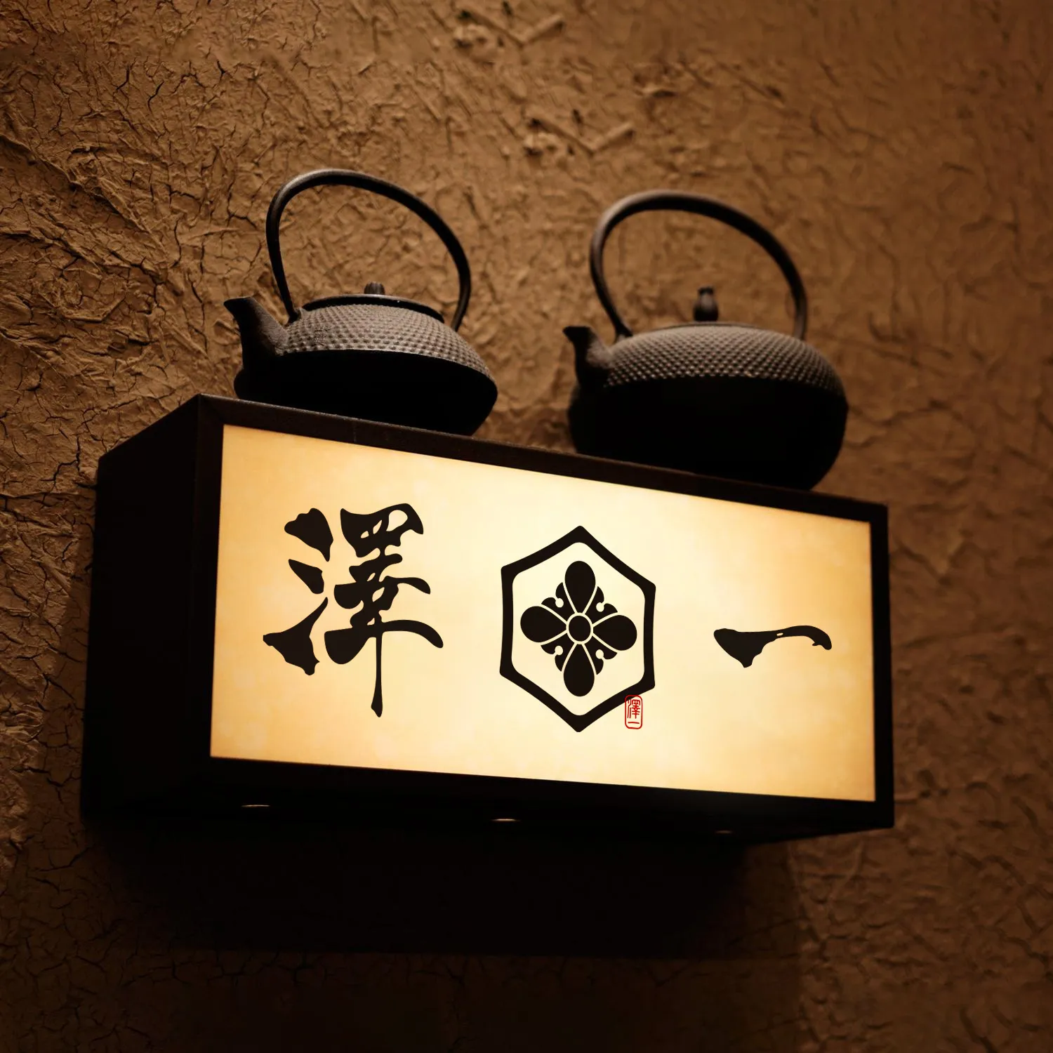 澤一燈箱招牌，上方擺放鐵壺